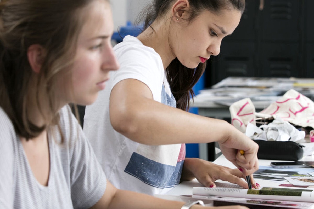 People working together on a hands-on creative project at a shared table.